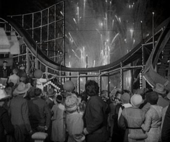 Movie still from “Sunrise” (1927), directed by F.W. Murnau – A group of people standing in front of an amusement park ride; Extreme Wide shot, High angle
