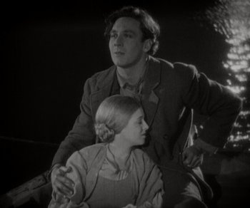 Movie still from “Sunrise” (1927), directed by F.W. Murnau – A man and a woman sitting next to each other on a boat; Medium shot, Low angle