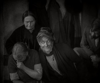 Movie still from “Sunrise” (1927), directed by F.W. Murnau – A group of people sitting next to each other; Medium shot, High angle