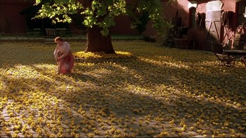 Movie still from “Sunshine” (1999), directed by István Szabó – A woman kneeling down under a tree filled with rubber ducky; Extreme Wide shot, High angle