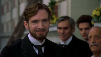 Movie still from “Sunshine” (1999), directed by István Szabó – A man in a suit and tie standing next to another man in a suit and tie; Close Up shot, Over the shoulder angle