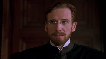 Movie still from “Sunshine” (1999), directed by István Szabó – A person wearing glasses and a suit; Close Up shot, Low angle