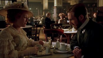Movie still from “Sunshine” (1999), directed by István Szabó – A man and a woman sitting at a table with cups of tea; Medium shot, Over the shoulder angle
