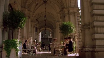 Movie still from “Sunshine” (1999), directed by István Szabó – A group of people sitting at a table outside; Extreme Wide shot, High angle