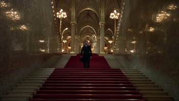 Movie still from “Sunshine” (1999), directed by István Szabó – A man in a suit and tie standing on a red carpet; Extreme Wide shot, Low angle