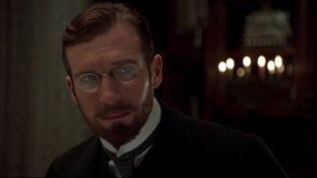 Movie still from “Sunshine” (1999), directed by István Szabó – A person wearing glasses and a suit; Close Up shot, Over the shoulder angle