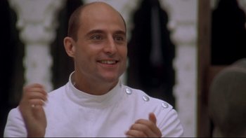 Movie still from “Sunshine” (1999), directed by István Szabó – A man in a white chef's outfit smiling; Close Up shot, Low angle