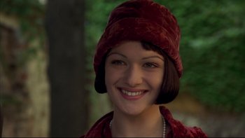 Movie still from “Sunshine” (1999), directed by István Szabó – A woman wearing a red hat smiling for the camera; Close Up shot, High angle