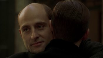 Movie still from “Sunshine” (1999), directed by István Szabó – A man's face with a man hugging it; Close Up shot, Over the shoulder angle