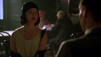Movie still from “Sunshine” (1999), directed by István Szabó – A woman wearing a black hat and a white dress; Medium shot, Over the shoulder angle