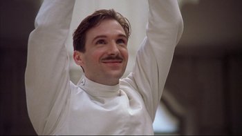 Movie still from “Sunshine” (1999), directed by István Szabó – A man with a mustache raises his arms in the air; Close Up shot, Low angle