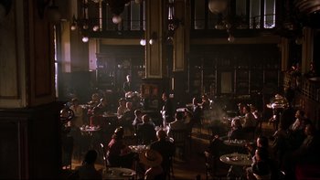 Movie still from “Sunshine” (1999), directed by István Szabó – A group of people sitting at tables in a room; Wide shot, High angle
