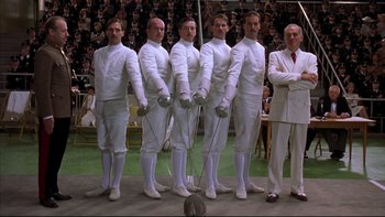 Movie still from “Sunshine” (1999), directed by István Szabó – A group of men standing in front of an audience holding fencing equipment; Wide shot, Low angle