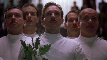Movie still from “Sunshine” (1999), directed by István Szabó – A group of men standing next to each other holding a plant; Close Up shot, Low angle