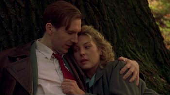 Movie still from “Sunshine” (1999), directed by István Szabó – A man and a woman embracing each other in front of a tree; Close Up shot, Low angle