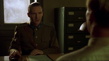 Movie still from “Sunshine” (1999), directed by István Szabó – A man in a military uniform sitting at a table; Medium shot, Over the shoulder angle