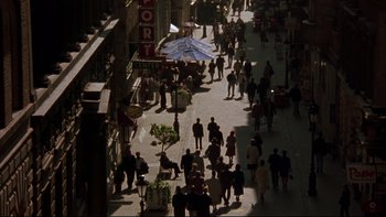 Movie still from “Sunshine” (1999), directed by István Szabó – A busy street with many people walking on the sidewalk; Extreme Wide shot, High angle