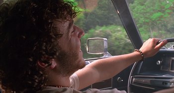 Movie still from “Super Troopers” (2001), directed by Jay Chandrasekhar – A young man driving a car with his mouth open; Close Up shot, Low angle