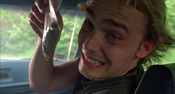 Movie still from “Super Troopers” (2001), directed by Jay Chandrasekhar – A man holding a cell phone up to his face; Close Up shot, Overhead angle