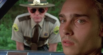Movie still from “Super Troopers” (2001), directed by Jay Chandrasekhar – A police officer and a man in a uniform; Close Up shot, Over the shoulder angle