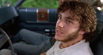 Movie still from “Super Troopers” (2001), directed by Jay Chandrasekhar – A young man sitting in the back seat of a car; Close Up shot, Low angle