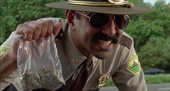Movie still from “Super Troopers” (2001), directed by Jay Chandrasekhar – A police officer holding a bag full of marijuana; Close Up shot, Low angle
