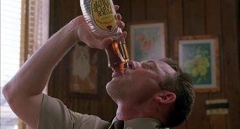Movie still from “Super Troopers” (2001), directed by Jay Chandrasekhar – A man in uniform drinking a beer from a bottle; Close Up shot, Low angle