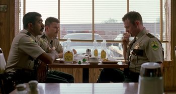 Movie still from “Super Troopers” (2001), directed by Jay Chandrasekhar – A group of men sitting at a table in front of a window; Medium shot, Low angle