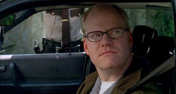 Movie still from “Super Troopers” (2001), directed by Jay Chandrasekhar – A person in a car wearing glasses; Close Up shot, Over the shoulder angle