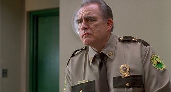 Movie still from “Super Troopers” (2001), directed by Jay Chandrasekhar – A man in a sheriff's uniform looks at the camera; Close Up shot, Low angle