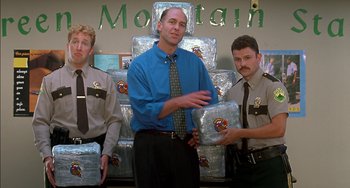 Movie still from “Super Troopers” (2001), directed by Jay Chandrasekhar – A group of men standing next to each other in a room; Medium shot, Low angle