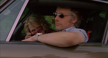 Movie still from “Super Troopers” (2001), directed by Jay Chandrasekhar – A man and a woman sitting in the back seat of a car; Close Up shot, Low angle