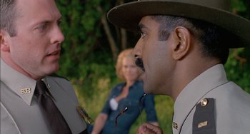 Movie still from “Super Troopers” (2001), directed by Jay Chandrasekhar – A man in a uniform talking to a woman in a uniform; Medium shot, Over the shoulder angle