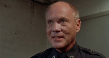 Movie still from “Super Troopers” (2001), directed by Jay Chandrasekhar – A man in a police uniform looking into the camera; Close Up shot, Low angle