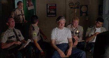 Movie still from “Super Troopers” (2001), directed by Jay Chandrasekhar – A group of men sitting in a room; Medium shot, Over the shoulder angle