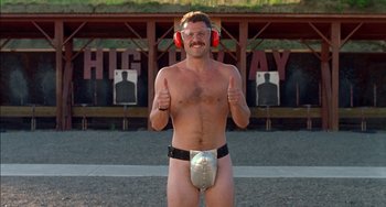 Movie still from “Super Troopers” (2001), directed by Jay Chandrasekhar – A man wearing a diaper and ear muffs standing in front of a target; Medium shot, Low angle