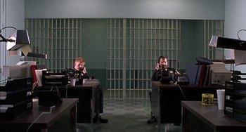 Movie still from “Super Troopers” (2001), directed by Jay Chandrasekhar – Two men sitting at a desk in front of laptops; Wide shot, High angle