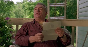 Movie still from “Super Troopers” (2001), directed by Jay Chandrasekhar – An older man holding a piece of paper in front of a window; Close Up shot, Low angle