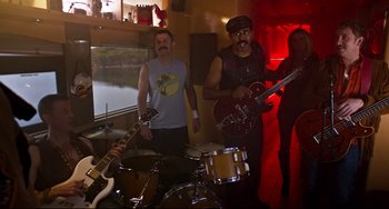 Movie still from “Super Troopers 2” (2018), directed by Jay Chandrasekhar – A group of men standing next to each other with instruments; Wide shot, High angle