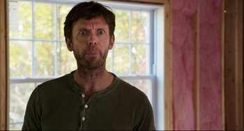 Movie still from “Super Troopers 2” (2018), directed by Jay Chandrasekhar – A person in a green shirt near a window; Medium shot, Over the shoulder angle