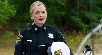 Movie still from “Super Troopers 2” (2018), directed by Jay Chandrasekhar – A police officer is holding a helmet in her hand; Close Up shot, Over the shoulder angle