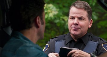 Movie still from “Super Troopers 2” (2018), directed by Jay Chandrasekhar – A police officer talking to a man holding a tablet; Close Up shot, Over the shoulder angle