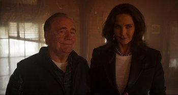 Movie still from “Super Troopers 2” (2018), directed by Jay Chandrasekhar – A man and a woman standing next to each other; Medium shot, Low angle