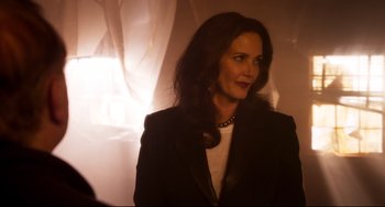 Movie still from “Super Troopers 2” (2018), directed by Jay Chandrasekhar – A woman in a black jacket standing in front of a curtain; Close Up shot, Over the shoulder angle