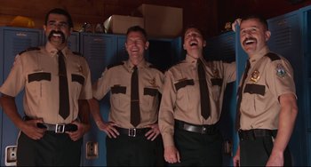 Movie still from “Super Troopers 2” (2018), directed by Jay Chandrasekhar – A group of men standing next to each other in uniforms; Medium shot, Low angle