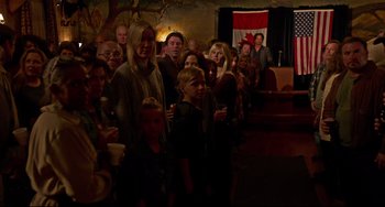 Movie still from “Super Troopers 2” (2018), directed by Jay Chandrasekhar – A group of people standing in front of a flag; Wide shot, High angle