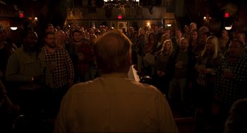 Movie still from “Super Troopers 2” (2018), directed by Jay Chandrasekhar – A crowd of people standing in front of an audience; Wide shot, High angle