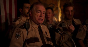 Movie still from “Super Troopers 2” (2018), directed by Jay Chandrasekhar – A group of men standing around a man in uniform; Close Up shot, Over the shoulder angle