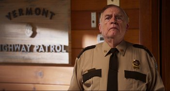 Movie still from “Super Troopers 2” (2018), directed by Jay Chandrasekhar – An older man in a uniform looking at the camera; Close Up shot, Low angle