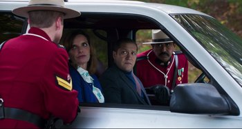 Movie still from “Super Troopers 2” (2018), directed by Jay Chandrasekhar – A man and a woman sitting in the back of a car; Medium shot, Over the shoulder angle